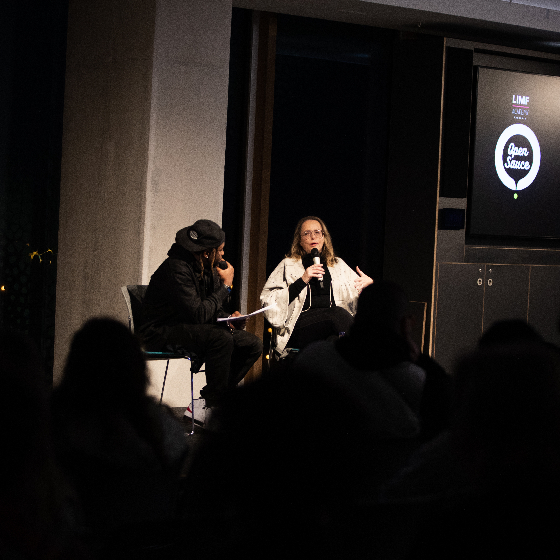 Two people dicussing on stage at a conference.