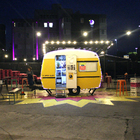 A small yellow caravan in the courtyard of Future Yard.