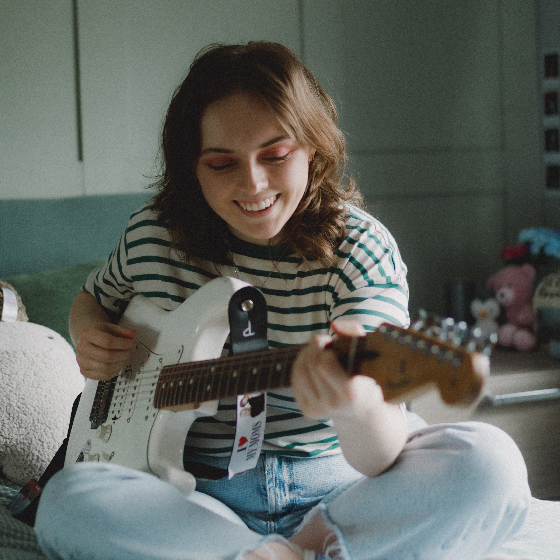 A young woman playing a guitar.
