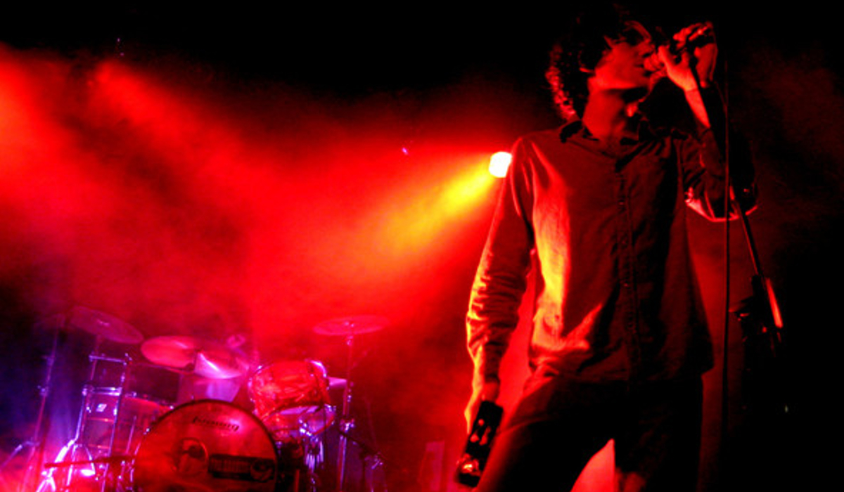 The Bandits performing on stage under red lights.