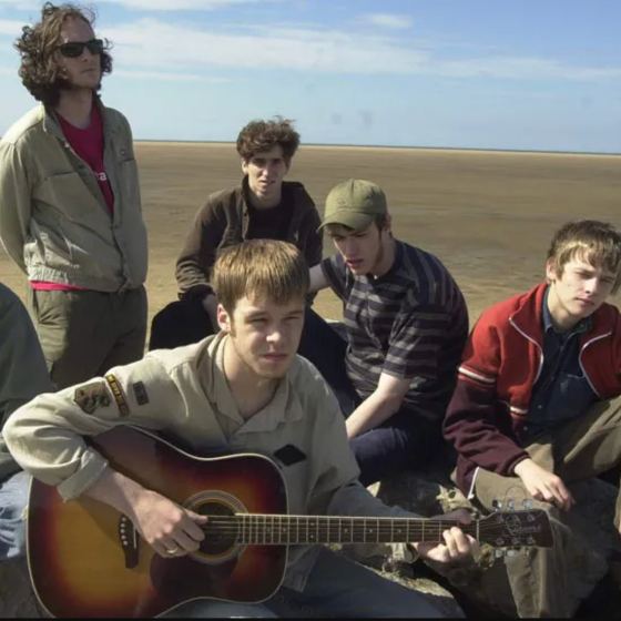 The musical band, The Coral, on the beach on a sunny day.