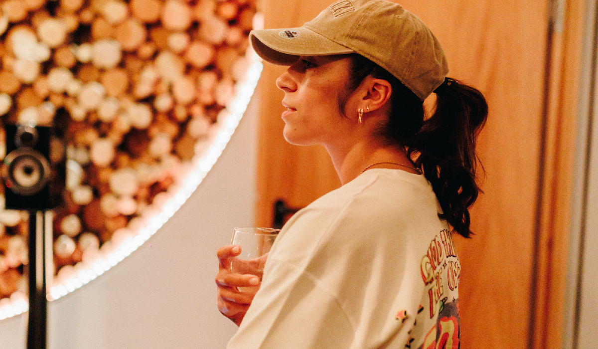 Chelcee Grimes wearing a cap and holding a glass of water.