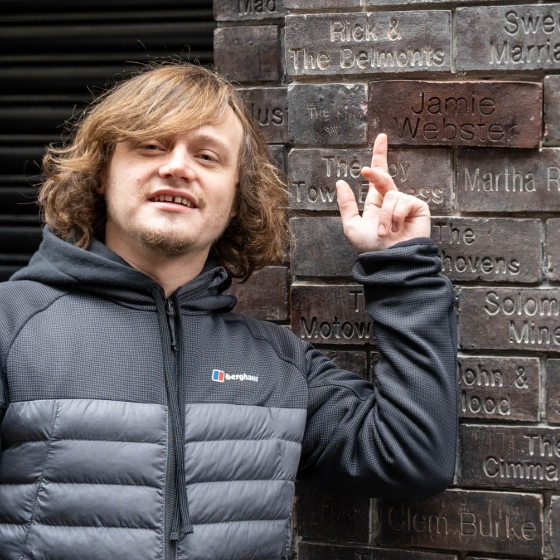 Jamie Webster pointing to his brick at The Cavern Wall of Fame.