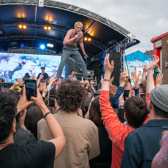 Shame performing at Liverpool Sound City 2019 at an outdoor stage.