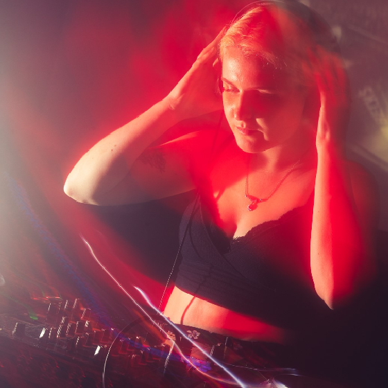 A girl DJ'ing with a red glare on the image.