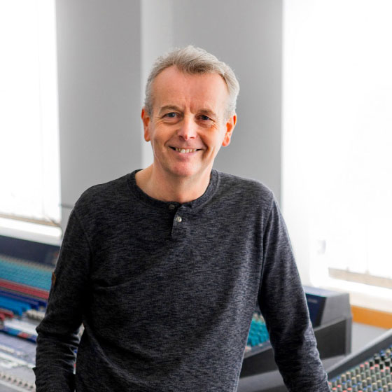 Andy Dockerty from Ad Lib Audio standing in front of a sound mixing console.