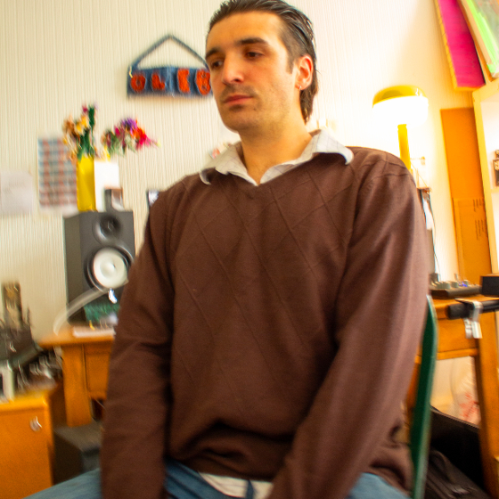 A man sitting in a chair, looking relaxed and comfortable.