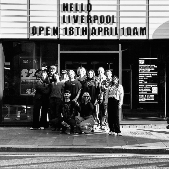 A black and white image of a group standing outside Rough Trade, Liverpool.