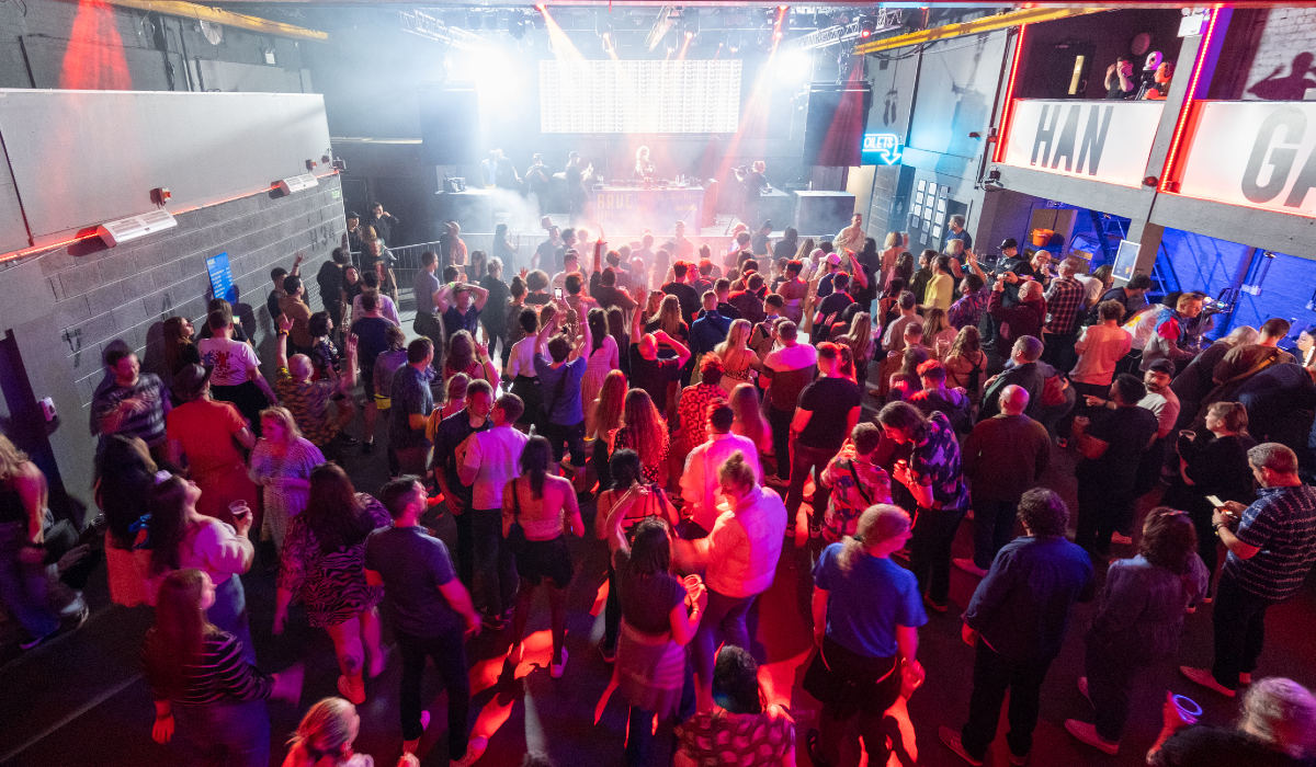 An overhead shot of the crowd at a busy, indoor music event.