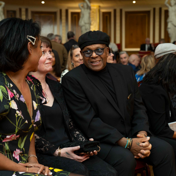 People chatting amongst themselves in the audience at a ceremony