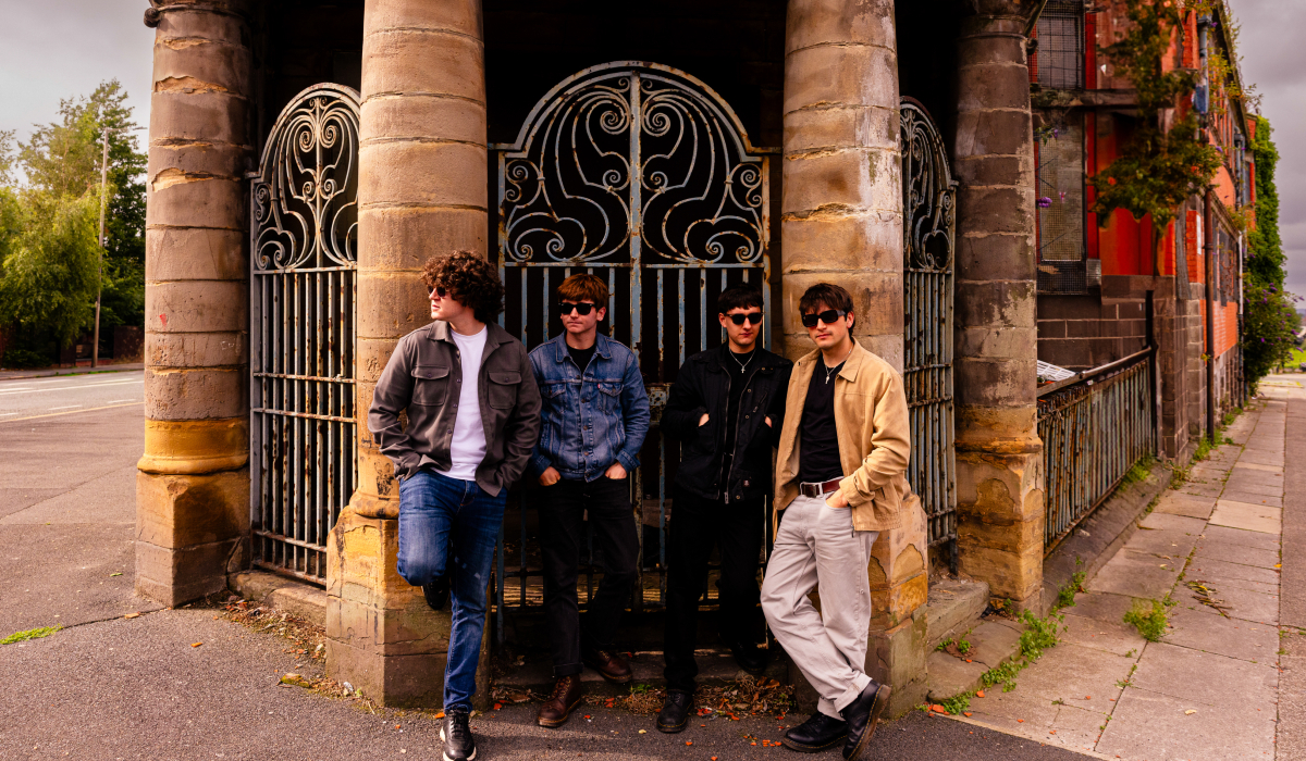 Four men standing outside a building in the daytime