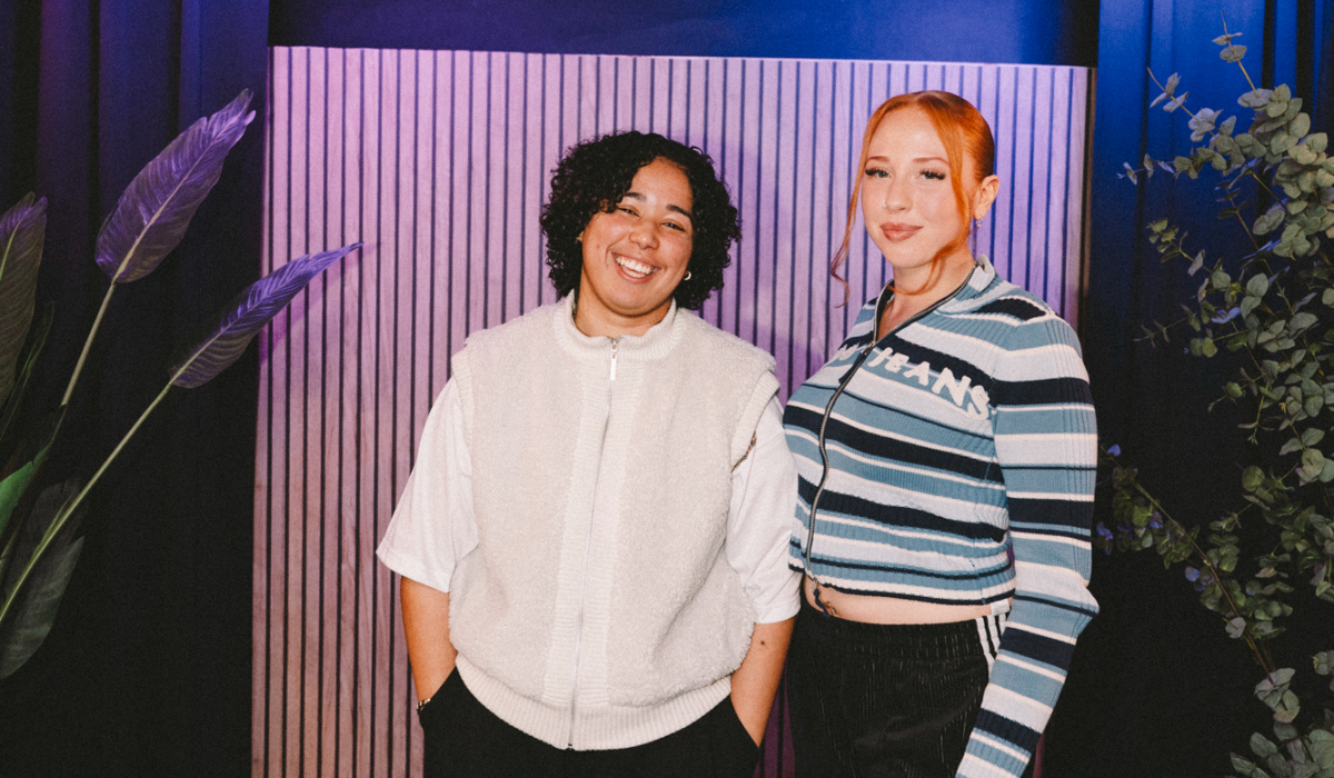 Two people standing together and smiling in a podcast studio