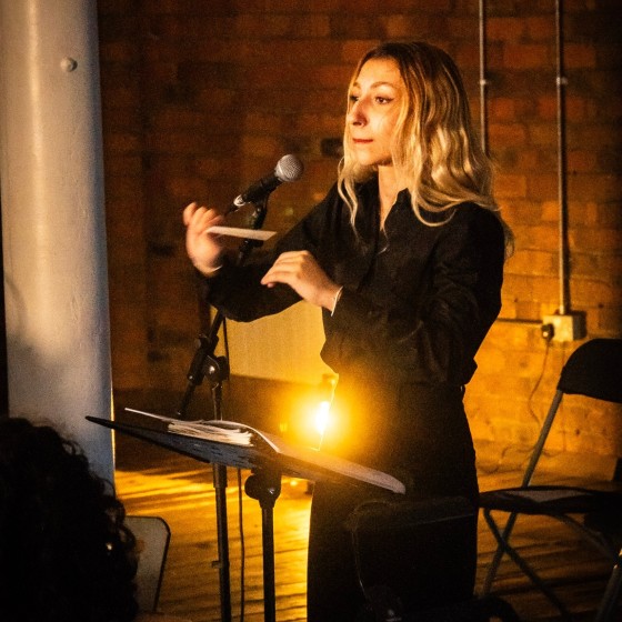 An image of a woman conducting in a dimly lit room