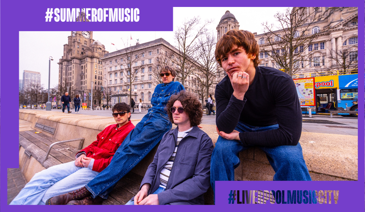 A photo of keyside a band of four people sitting on Pier Head in Liverpool.