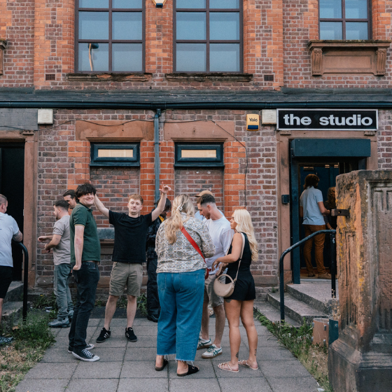 A group of people stood outside a building called The Studio.
