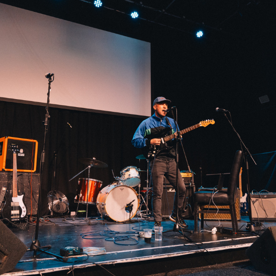 A person on a stage playing a guitar.