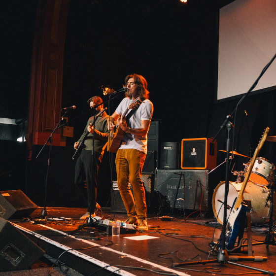 A person on a stage playing a guitar.